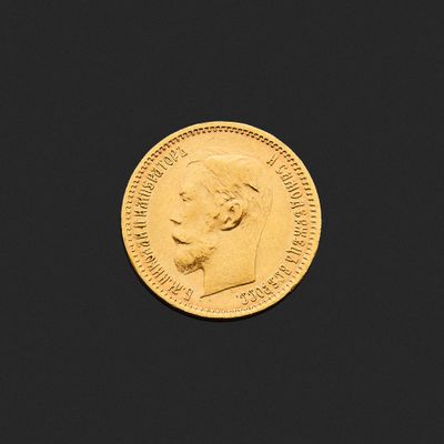 gros plan d'une pièce d'or sur une surface noire