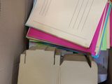 a cardboard box filled with files and papers on the floor
