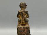 an image of a statue of a person sitting on top of a block