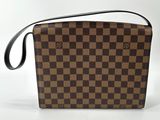 a brown and black checkered purse sitting on top of a white surface