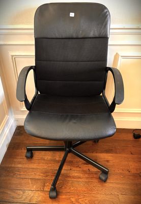 black leather office chair with armrests and casteors on hardwood floor