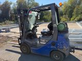a blue fork truck that is parked on the side of the road