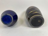 two blue vases sitting next to each other on a white surface
