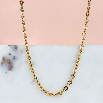 a gold chain necklace on a marble surface