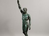 statue en bronze représentant un homme tenant une raquette de tennis, posée sur un socle en marbre