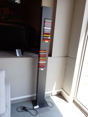 une photo montrant une haute pile de livres dans un salon