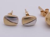 two pairs of gold and silver stud earrings on a white surface