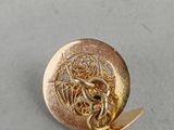 a small gold button with a dragon on it