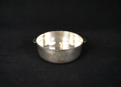 a silver plated bowl on a black background
