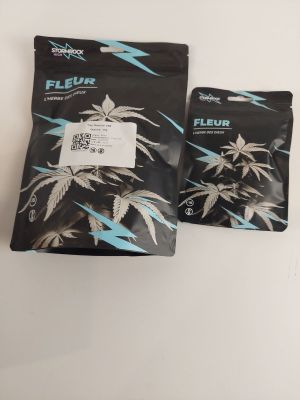 deux sachets de cannabis « fleur » posés sur une table blanche