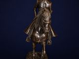 a bronze statue of a man on a horse with a hat