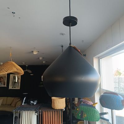 une grande lampe noire suspendue au plafond dans une pièce