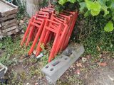 une pile de chaises rouges posées dans l'herbe