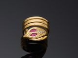 a close up of a gold ring with pink stones on a black surface