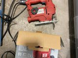 an image of a red and black corded jig saw next to a box of tools
