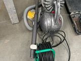 un aspirateur et un tuyau posés par terre à côté d'une boîte à outils