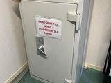 a safe box with a sign on it in the corner of a room