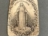 a small bag with a picture of the virgin mary on it