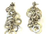 deux paires de boucles d'oreilles posées sur une surface blanche