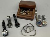 many watches and bracelets laid out on a table