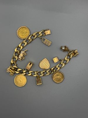 Gros plan sur un bracelet en or orné de pièces de monnaie