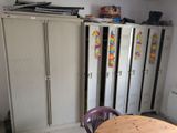 cabinets and a table in a room with a lot of clutter on top of them