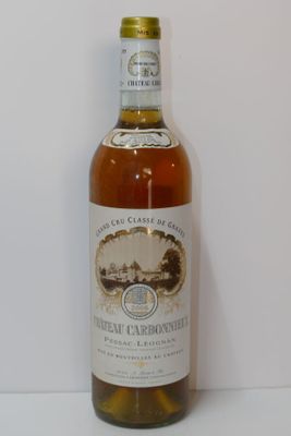 une bouteille de vin blanc posée sur une table, avec un mur blanc en arrière-plan