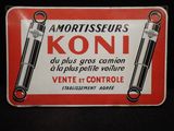 un gros plan d'un panneau posé sur une surface noire avec un fond rouge