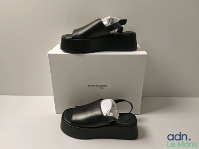 the black shoes are sitting on top of a white box
