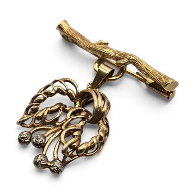 une image montrant un gros plan d'un collier en or orné d'une branche d'arbre