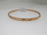 gros plan d'un bracelet en or sur une surface blanche