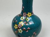 a blue vase with flowers on it on a white surface