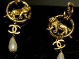 two pairs of gold and pearl earrings on a black surface