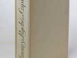 un vieux livre posé sur une table blanche à côté d'un mur blanc