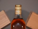 a bottle of whiskey sitting on a table next to a wooden box