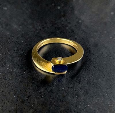 an image of a gold ring with a blue stone in it