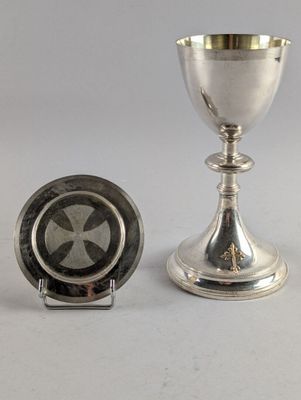 une coupe en argent posée à côté d'une assiette en argent sur une table