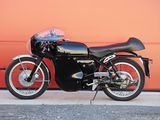 a black motorcycle parked in front of a red garage door