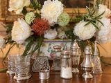 une table sur laquelle se trouvent un vase de fleurs et de l'argenterie