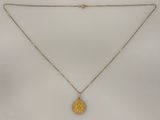 un collier composé d'une pièce en or suspendue à une chaîne en or