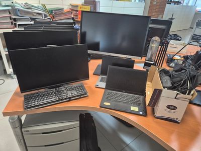 a desk with two laptops and a monitor on it