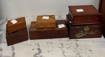 trois boîtes en bois munies d'étiquettes, posées sur un plan de travail en marbre