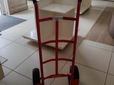 a red hand truck that is sitting in the middle of a room