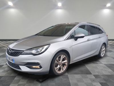 une voiture argentée est garée sur le sol à carreaux d'un garage