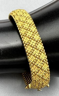 a close up of a gold bracelet on top of a black ring