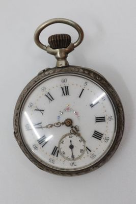 a silver pocket watch with roman numerals on it