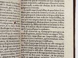 an open book with black writing on it sitting on top of a table