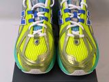 a pair of yellow and blue running shoes on top of a box