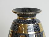 a black and gold vase sitting on a table