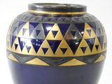 a blue and gold vase sitting on a white surface